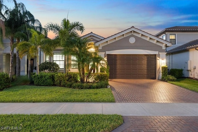 view of front of home featuring a garage and a lawn