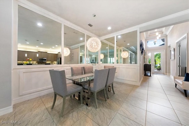 dining space featuring light tile patterned flooring, ornamental molding, and an inviting chandelier