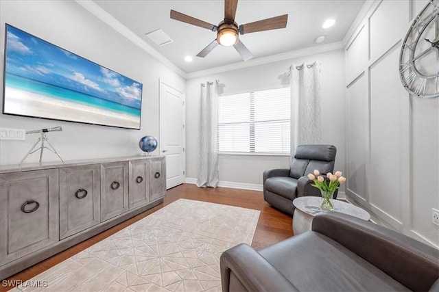 living area featuring light wood-type flooring, ceiling fan, and ornamental molding