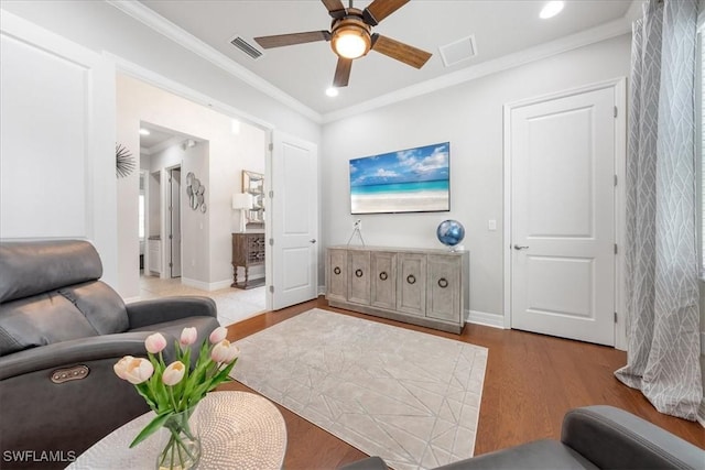 living room featuring light hardwood / wood-style flooring, ceiling fan, and ornamental molding