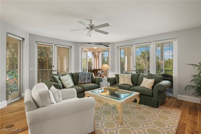 living room featuring french doors, light wood-type flooring, and ceiling fan