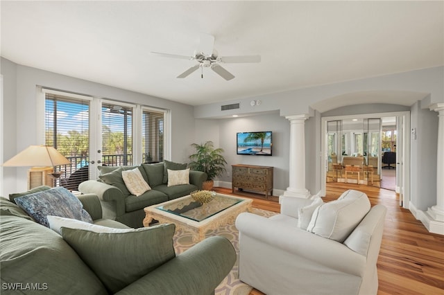 living room with ceiling fan, light hardwood / wood-style floors, and ornate columns