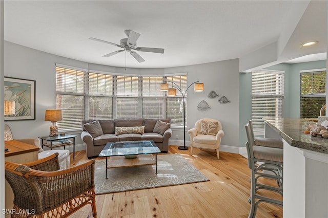 living room with light hardwood / wood-style floors and ceiling fan