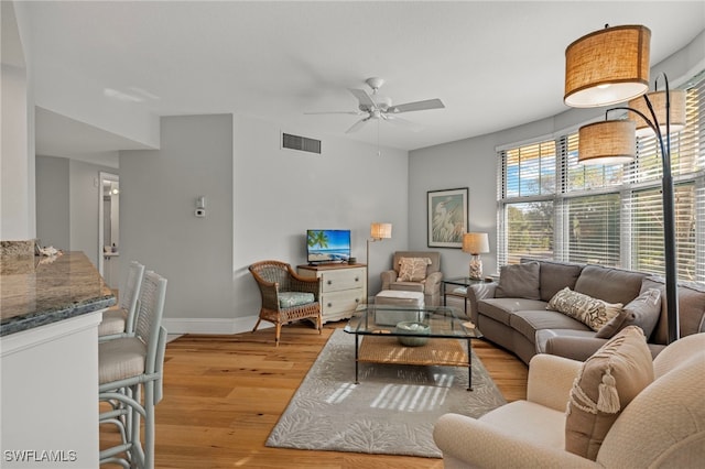 living room with ceiling fan and light wood-type flooring