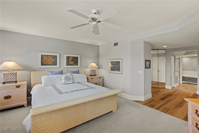 bedroom featuring ceiling fan, light wood-type flooring, and a closet