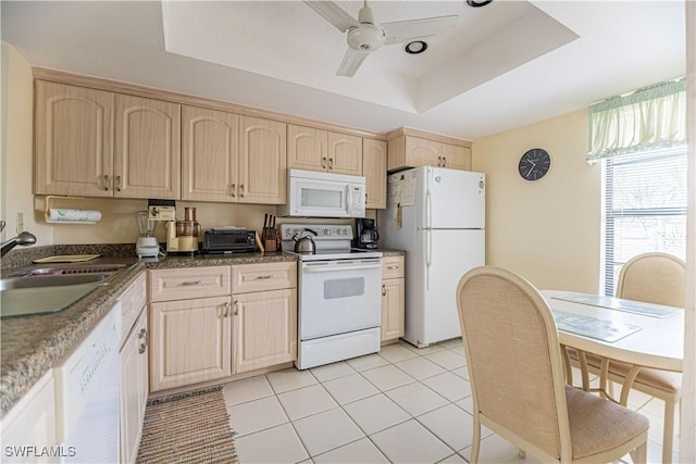 kitchen with light brown cabinets, white appliances, a raised ceiling, and ceiling fan