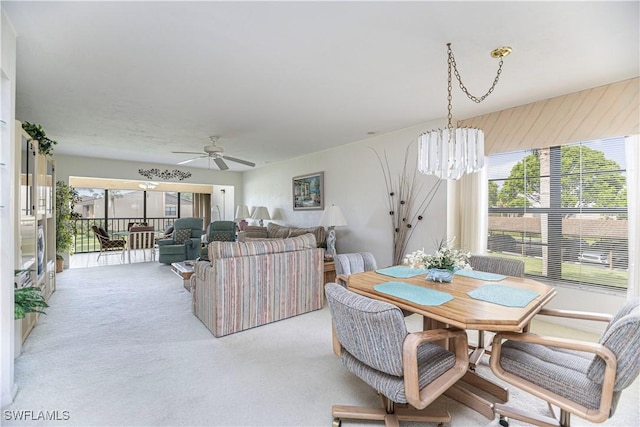 carpeted dining space with ceiling fan with notable chandelier