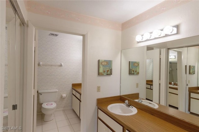 bathroom with tile patterned flooring, vanity, and toilet