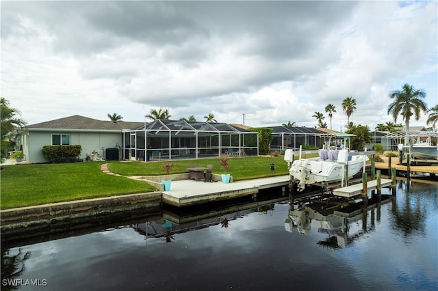 view of dock with a lanai, a yard, and a water view