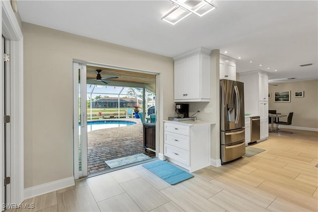 kitchen featuring ceiling fan, white cabinetry, and stainless steel appliances