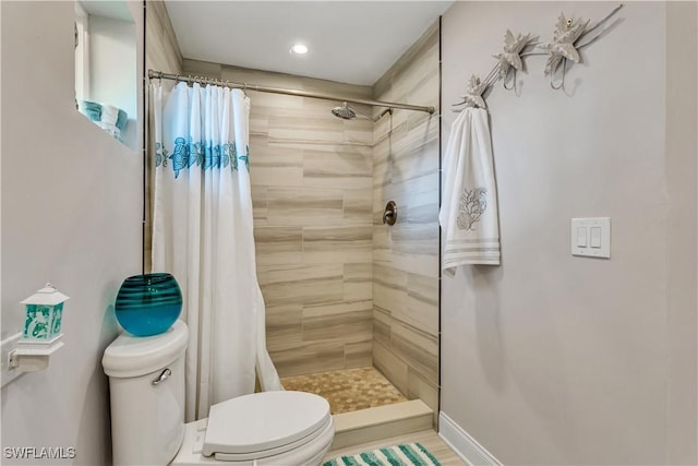 bathroom featuring a shower with shower curtain and toilet