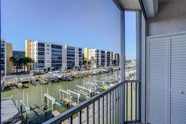 balcony featuring a water view and a dock