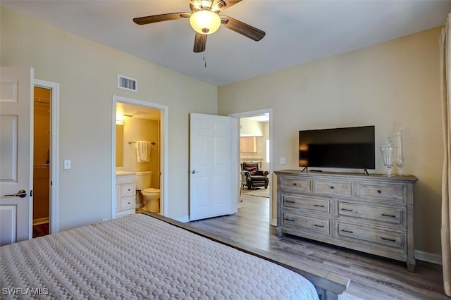 unfurnished bedroom with ceiling fan, ensuite bathroom, and light hardwood / wood-style flooring