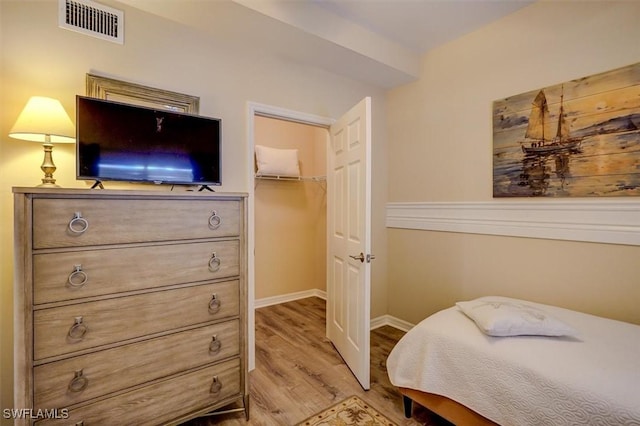 bedroom featuring light hardwood / wood-style floors, a spacious closet, and a closet