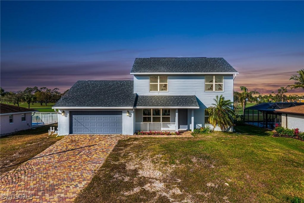 view of front property with a lawn, a porch, and a garage