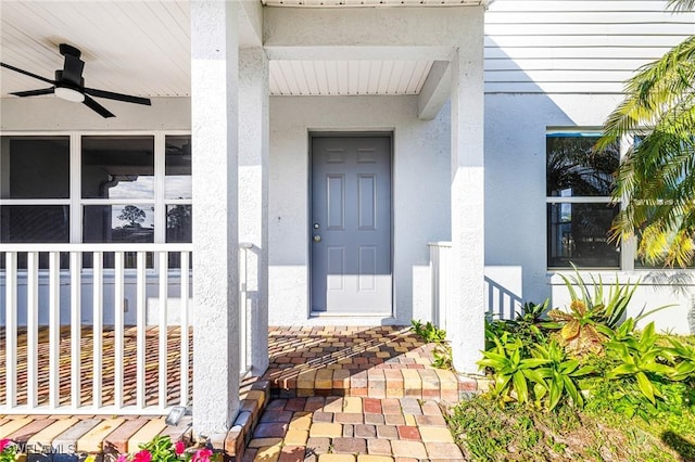 entrance to property with ceiling fan and a porch