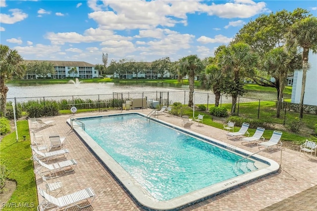 view of pool with a water view and a patio