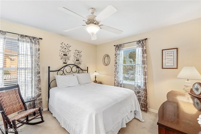 carpeted bedroom featuring multiple windows and ceiling fan