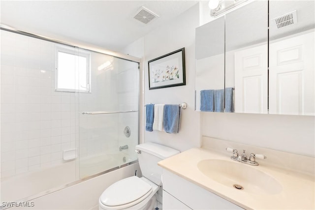 full bathroom featuring vanity, enclosed tub / shower combo, and toilet