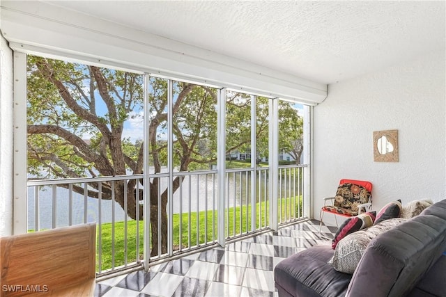 sunroom featuring a water view