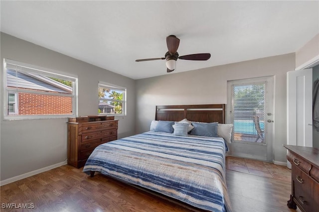 bedroom with dark wood-type flooring, access to outside, and baseboards