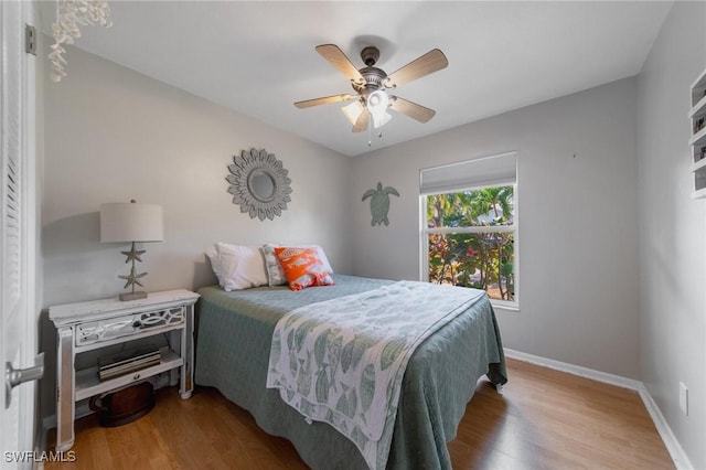 bedroom with ceiling fan, baseboards, and wood finished floors