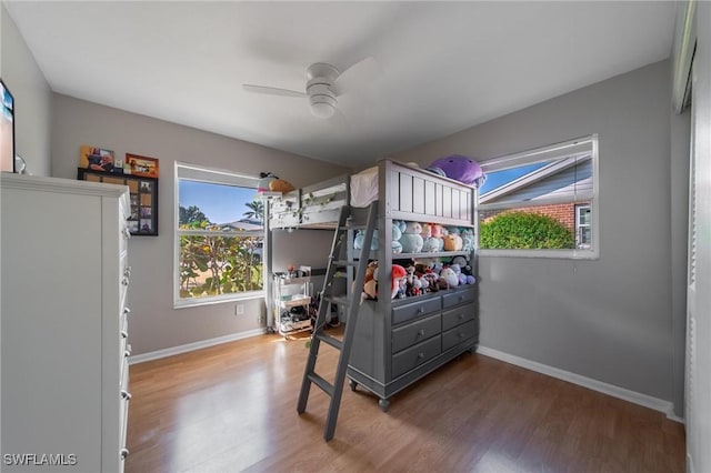 bedroom with wood finished floors, a ceiling fan, and baseboards