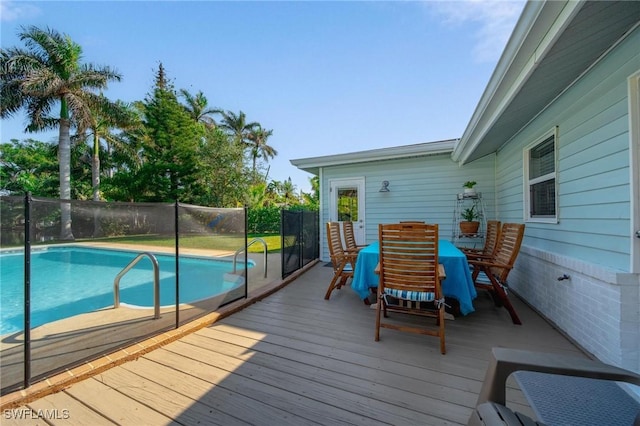 deck with a fenced in pool, outdoor dining space, and fence