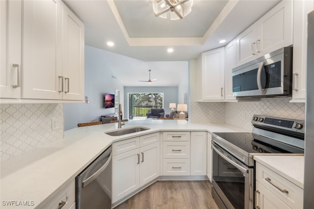 kitchen featuring stainless steel appliances, white cabinetry, and sink