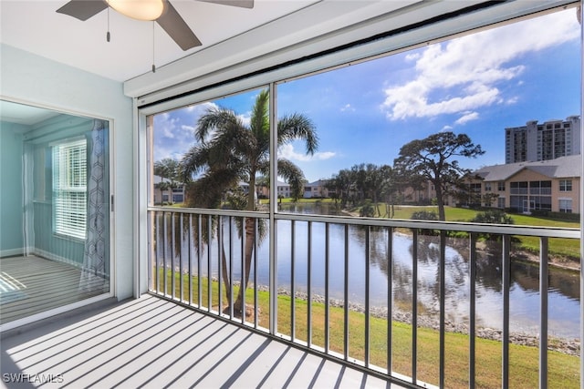 unfurnished sunroom featuring a water view, ceiling fan, and plenty of natural light