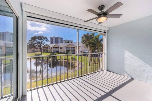 sunroom / solarium with a water view and ceiling fan