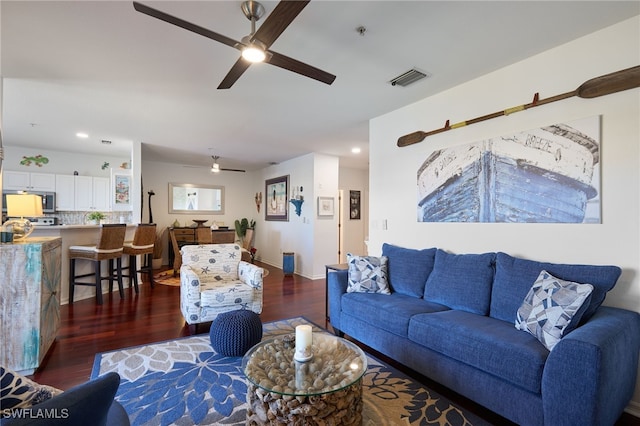 living room featuring ceiling fan and dark hardwood / wood-style flooring