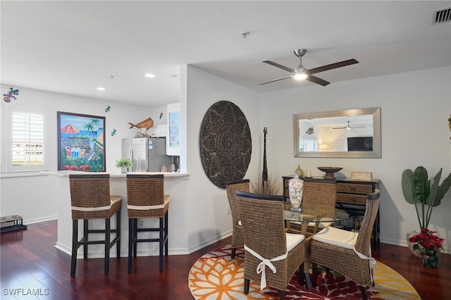 dining space with ceiling fan, dark hardwood / wood-style flooring, and a textured ceiling