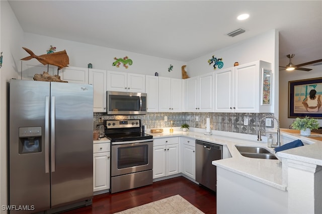 kitchen featuring light stone countertops, stainless steel appliances, ceiling fan, sink, and white cabinets