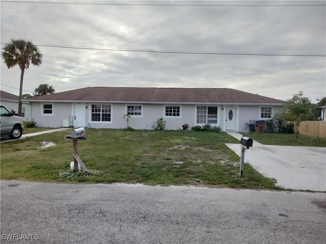 single story home featuring a front lawn