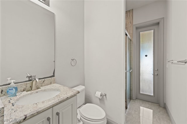 bathroom with tile patterned floors, vanity, a healthy amount of sunlight, and toilet