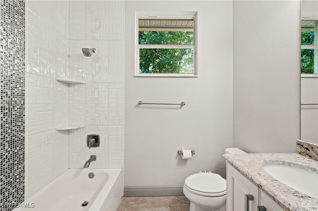 full bathroom with tiled shower / bath, vanity, and toilet