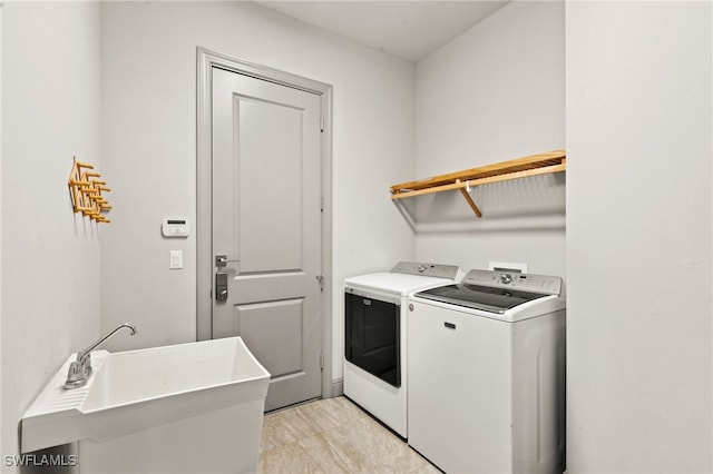 laundry area with independent washer and dryer and sink