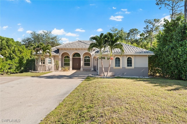 mediterranean / spanish-style house featuring covered porch and a front lawn