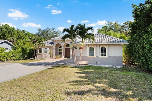 mediterranean / spanish house featuring a front lawn