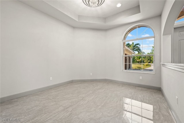 unfurnished room featuring a tray ceiling