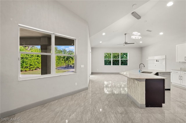 kitchen featuring a breakfast bar, ceiling fan, sink, white cabinets, and an island with sink