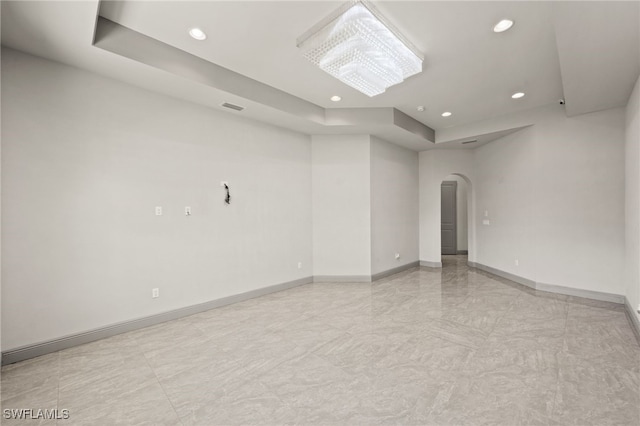 unfurnished room with a raised ceiling