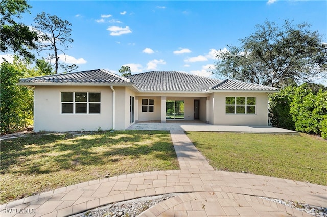 back of property with a lawn and a patio area