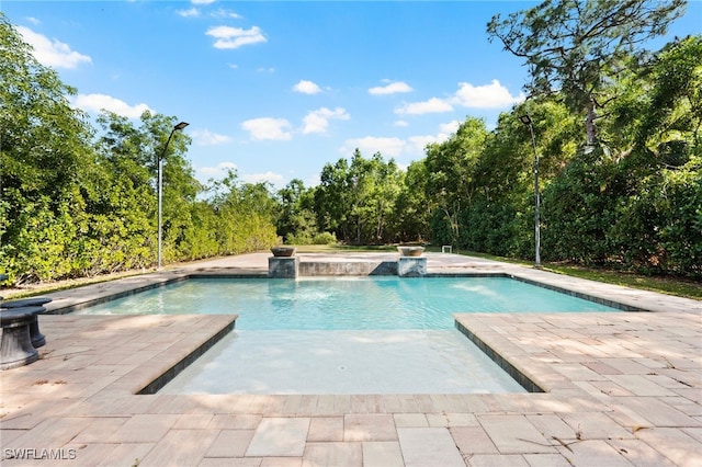 view of swimming pool with pool water feature, a patio, and a jacuzzi