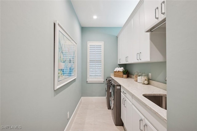 laundry room with sink, light tile patterned floors, cabinets, and independent washer and dryer