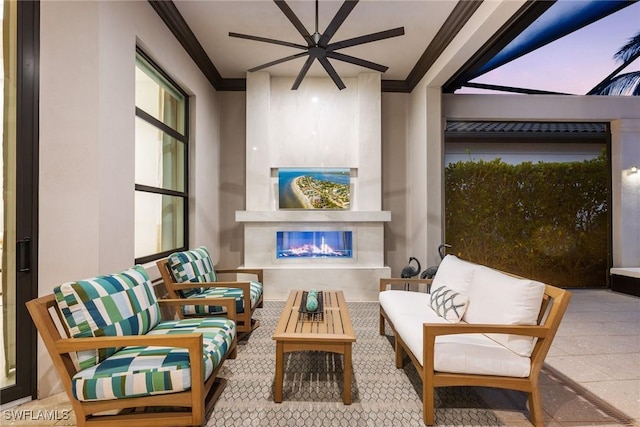 living area with an outdoor fireplace, ceiling fan, and ornamental molding