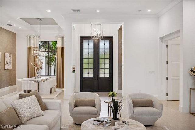 tiled entrance foyer featuring ornamental molding, french doors, and an inviting chandelier