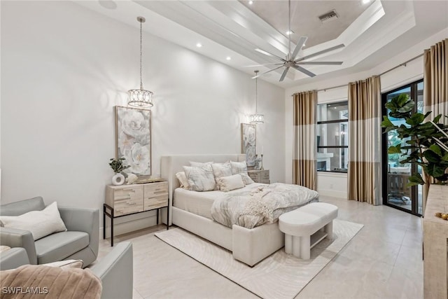 bedroom with a chandelier, a tray ceiling, and a towering ceiling