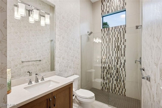 bathroom featuring toilet, a shower with door, and vanity